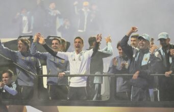 El saludo de la selección argentina durante su llegada a Ezeiza La selección argentina muestra un gesto conmovedor hacia sus seguidores en su llegada al predio de Ezeiza desde el aeropuerto.